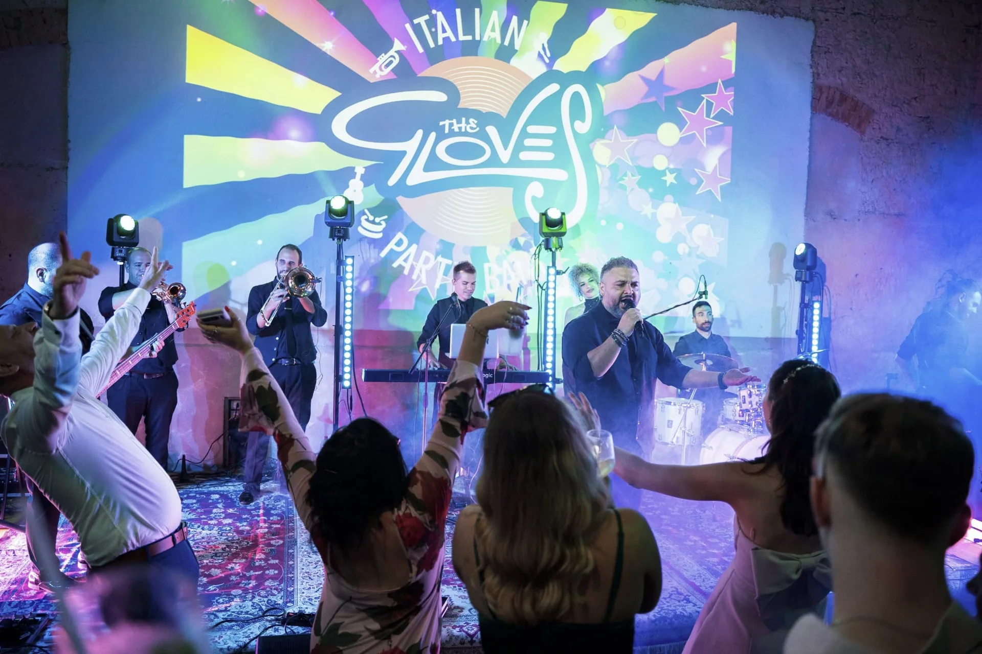 The Gloves performing on stage in front of guests on the dance floor
