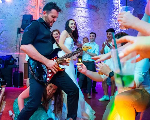The Gloves guitarist performing among wedding guests