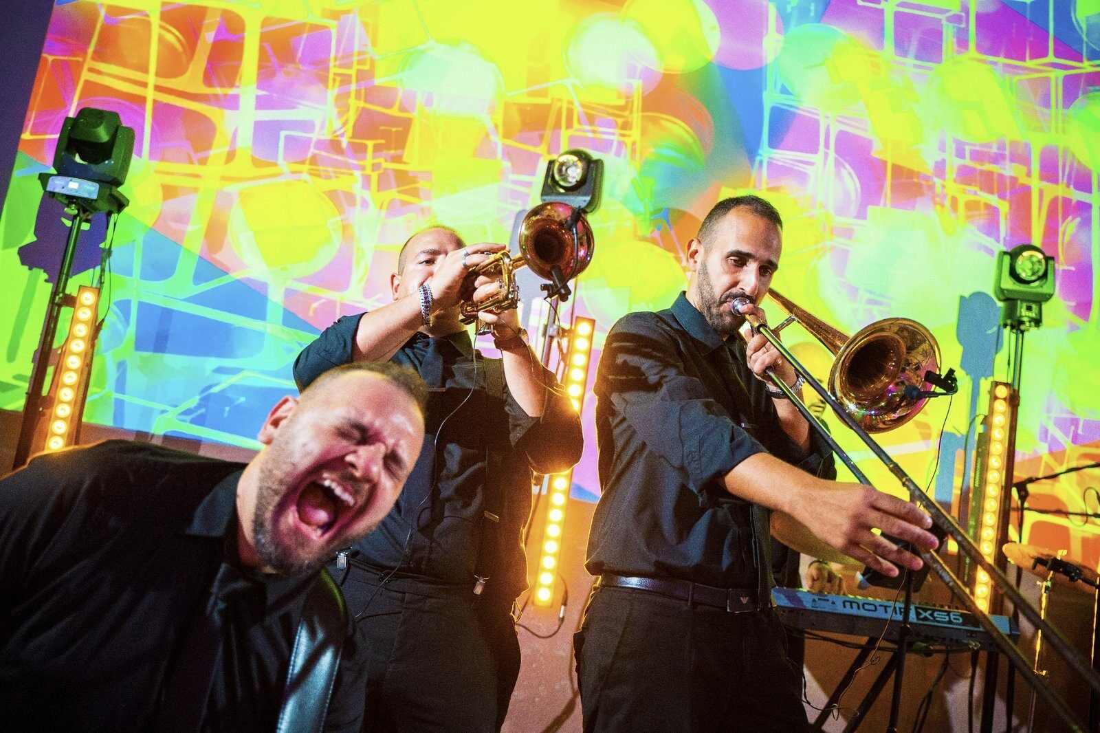 Brass section of a wedding band playing trumpet and trombone during a vibrant live show in Italy