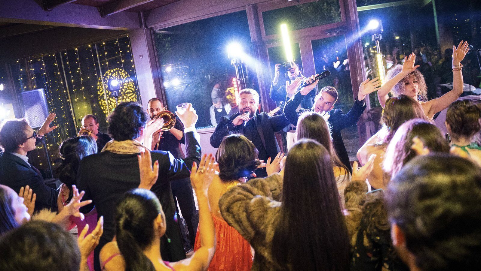 Wedding singer interacting with guests while the band plays live at a luxury wedding in Italy